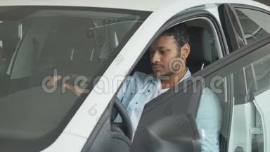 一个男人坐在开着车门的车里的画像